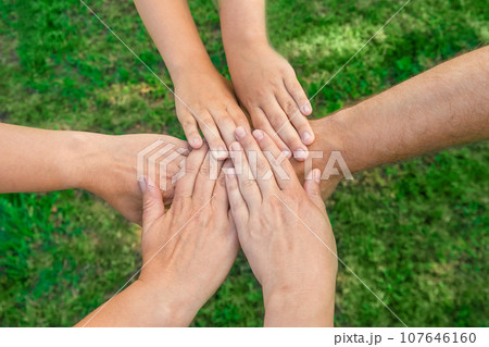 Joined hands as a team. Business teamwork. Close up group of multiracial friends meeting join hands together. Diversity people. Partnership volunteer community. Diverse multiethnic Partners. Top View Joined hands as a team. Business teamwork. Close up group of multiracial friends meeting join hands together. Diversity people. Partnership volunteer community. Diverse multiethnic Partners. Top View 107646160