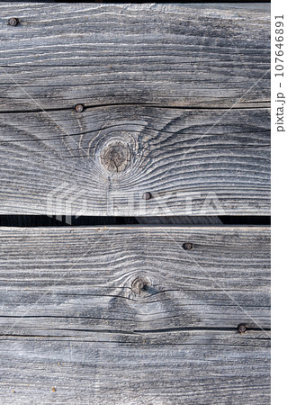 Elements of the walls of a wooden old village house. Wooden Log cabin walls texture. Weathered surface of an old wooden log house close-up. Old wooden log building in winter close-up. Elements of the walls of a wooden old village house. Wooden Log cabin walls texture. Weathered surface of an old wooden log house close-up. Old wooden log building in winter close-up. 107646891