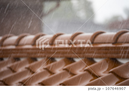 大粒の雨が屋根瓦に打ち付けるイメージ｜雨イメージ｜豪雨イメージ 107646907