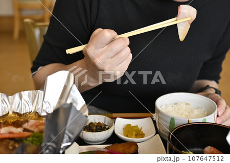 ご飯を食べる女性の口元 107647512