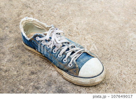 Dirty old shoes on the floor 107649017