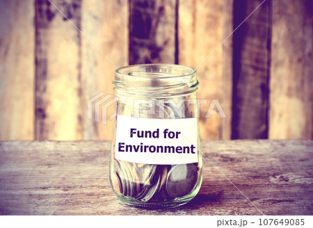 Coins in glass money jar with Fund for the Environment label Coins in glass money jar with Fund for the Environment label 107649085