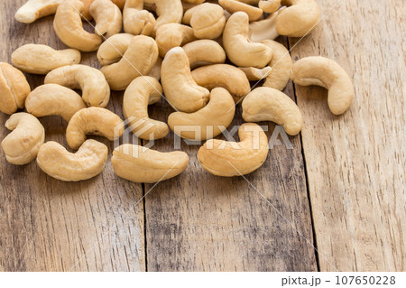 Cashew nuts scattered on a wooden table 107650228