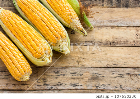 Fresh corn on wooden table background Fresh corn on wooden table background 107650230