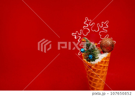 Ice Cream Cone with Christmas Decoration on red background. Minimal Christmas Concept 107650852