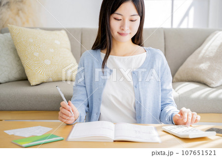 家計簿をつける女性 家計簿をつける女性 107651521