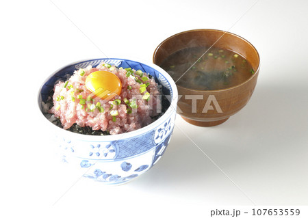 小葱と卵黄が乗っているマグロのたたき丼と熱々のお味噌汁 107653559