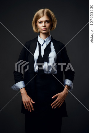 blonde businesswoman looking at camera on black background 107655530