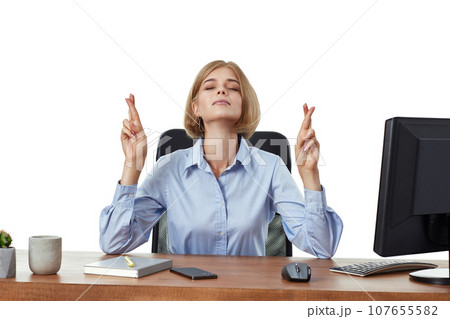 businesswoman showing fingers crossed for good luck in office 107655582