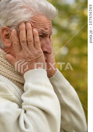 Portrait of an old man having a headache Portrait of an old man having a headache 107656369