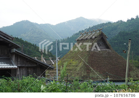 美山の茅葺屋根と山と空 美山の茅葺屋根と山と空 107656786