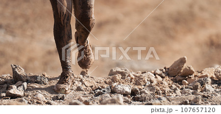 Mud race runners detail of the legs, muddy running shoes a run in the mud 107657120