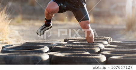 Mud race runners, tries to make it through the tire trap 107657127