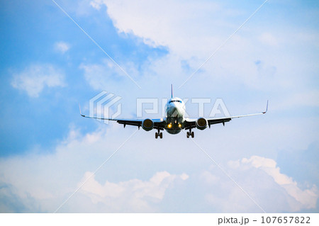 青空の福岡空港を着陸してくるジェット機 107657822
