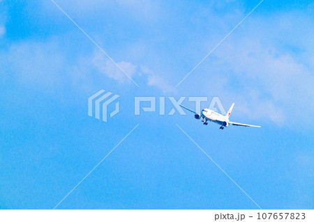 青空の福岡空港を着陸してくるジェット機 107657823