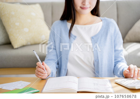 家計簿をつける女性 107658678