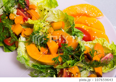 Tasty salad of baked pumpkin, cherry tomatoes, sesame and sauce Tasty salad of baked pumpkin, cherry tomatoes, sesame and sauce 107659643