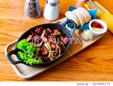 Fried sausages on onions Fried sausages on onions 107660175