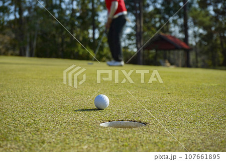 Golfers are putting golf in the evening golf course golf backglound. Golfers are putting golf in the evening golf course golf backglound. 107661895