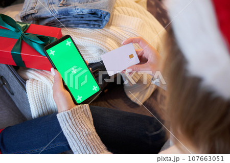 Mockup of smartphone and payment card. A woman pays for a holiday trip or books a hotel. Mockup of smartphone and payment card. A woman pays for a holiday trip or books a hotel. 107663051