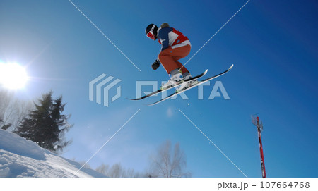 Skiers athletes compete going down from ski mountain. AI generated. 107664768