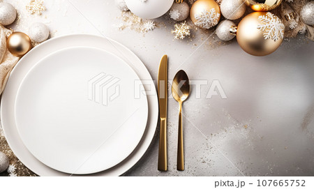 Modern holiday table setting, white empty plates, decorations from glass shiny balls, on a light table 107665752