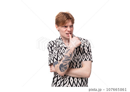 young smart man with red hair dressed in a short sleeve shirt posing on a white background young smart man with red hair dressed in a short sleeve shirt posing on a white background 107665861