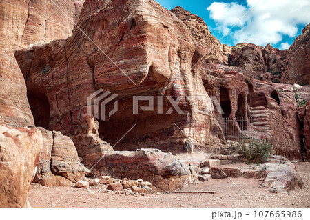 View of the Temples and caves carved into the sandstone rock in the gorge. Petra, Jordan 107665986