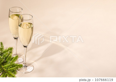 Two champagne glasses on a beige 107666119
