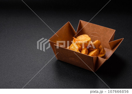 Delicious crispy fried potato wedges with salt, spices and herbs 107666856