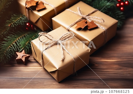 Christmas zero waste. Gift box packed in craft paper, decorated with natural twine and spruce branches 107668125