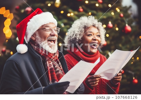 African American man and woman choir carolers singing traditional Christmas carols outdoors 107668126