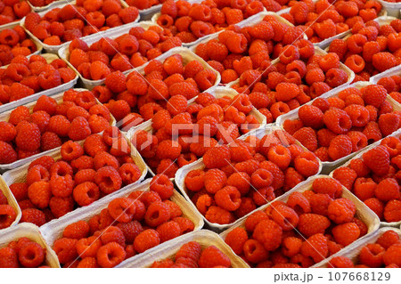 Fresh raspberries in paper containers on a farmers market 107668129