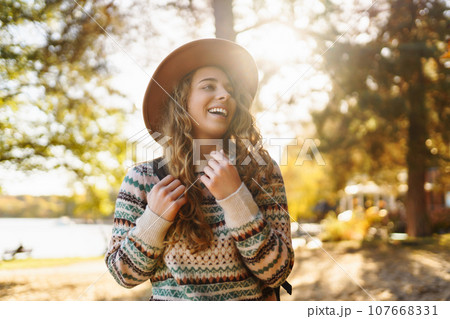 Stylish woman enjoying autumn weather in the sunny park. Enjoying nature. Fashion, style concept. Stylish woman enjoying autumn weather in the sunny park. Enjoying nature. Fashion, style concept. 107668331