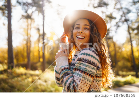 Outdoor atmospheric lifestyle. portrait of beautiful woman having fun in autumn forest. Warm autumn 107668359
