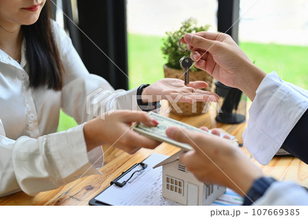 Male real estate agent receiving money from a client after signing contract in office. Real estate, mortgage, loan and insurance 107669385