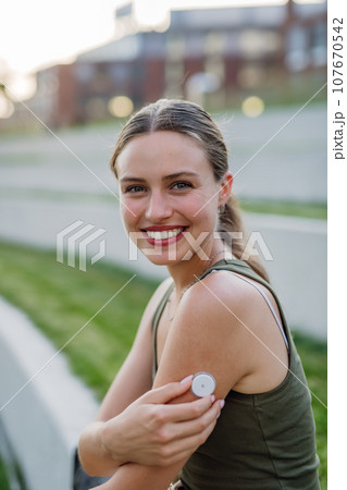 Diabetic woman with continuous glucose monitor on arm. Diabetic woman with continuous glucose monitor on arm. 107670542