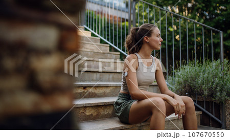 Diabetic woman preparing for outdoor run in the city. Young woman wearing continuous glucose monitor during exercising. Concept of exercise and diabetes. Banner with copy space. 107670550