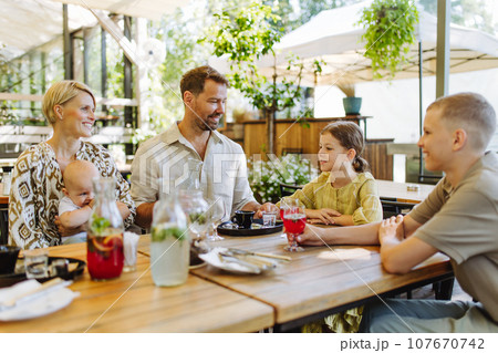 Big family with children and a small baby at family dinner in a restaurant. 107670742