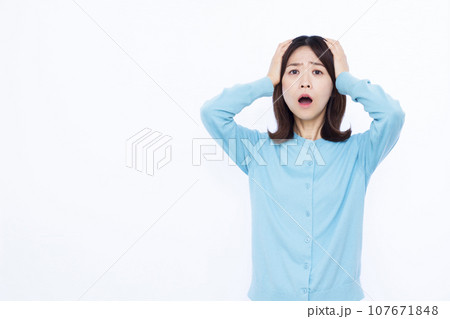 白い背景の前で頭を抱えておどろく30代の女性 107671848