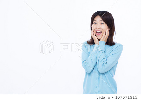 白い背景の前で笑顔でビックリしている30代の女性 白い背景の前で笑顔でビックリしている30代の女性 107671915
