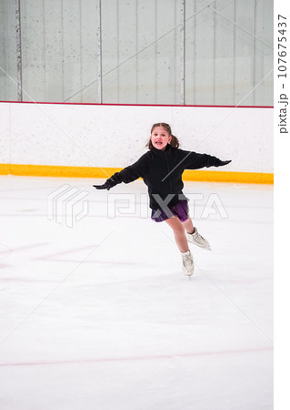 Little girl practicing before her figure skating competition at the indoor ice rink. 107675437
