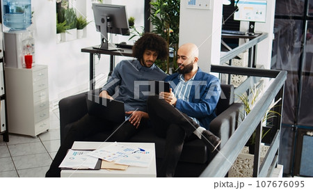 Business partners work on investment to increase profit, analyzing statistics online on laptop in open space. Happy company employees checking new project information, development strategy. Business partners work on investment to increase profit, analyzing statistics online on laptop in open space. Happy company employees checking new project information, development strategy. 107676095