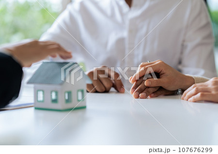 Young couple is listening to home purchase agreement with bank by taking out joint loan 107676299