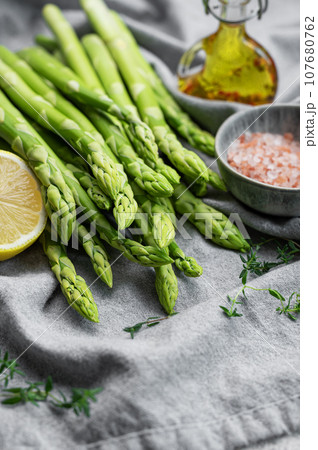 Bunch of raw asparagus stems with different spices Bunch of raw asparagus stems with different spices 107680762
