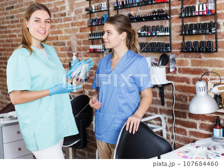 women nail masters standing at workplace women nail masters standing at workplace 107684460