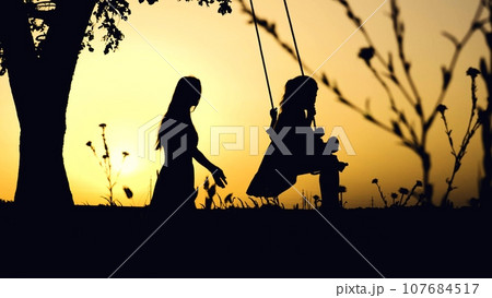 Mother riding little girl on swings dark silhouettes in park at sunset light. Little girl playing swings with mother silhouettes at dusk. Family of mother and daughter play swings in summer evening Mother riding little girl on swings dark silhouettes in park at sunset light. Little girl playing swings with mother silhouettes at dusk. Family of mother and daughter play swings in summer evening 107684517