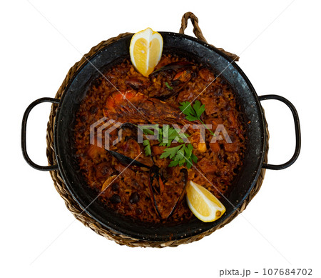 Traditional seafood paella with shrimps, squid and clams served in paellera 107684702