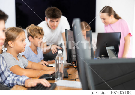 Portrait of female schoolgirl at computers in computer class 107685180