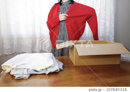 今年は赤がマストバイ 洋服をネットショッピングで購入 早速着てみる女性 今年は赤がマストバイ 洋服をネットショッピングで購入 早速着てみる女性 107685338
